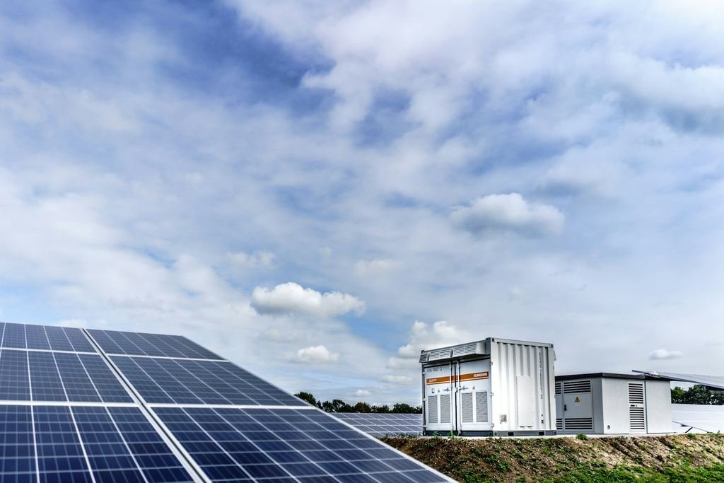 Contenedores de almacenamiento de energía junto a un campo de paneles solares